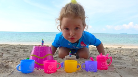 萌娃小可爱在沙滩玩游戏，用沙子堆了个小蛋糕，这是给谁过生日呢