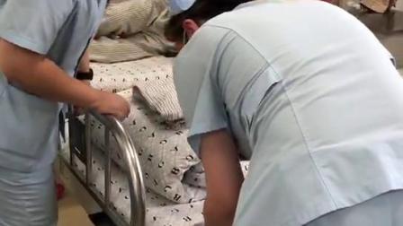 脊柱二科护士刘泽明和谭晓燕为患者铺床让患者有一个舒适的环境
